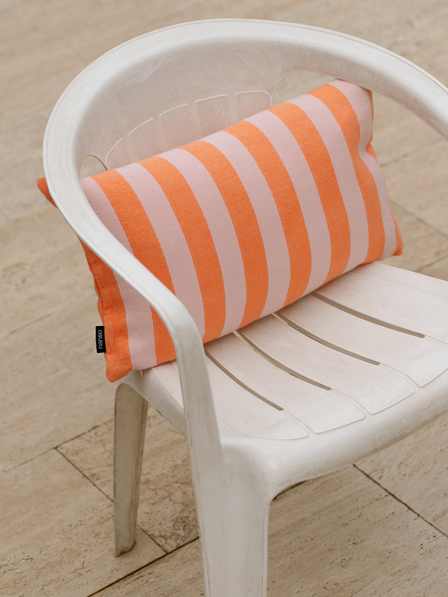 Nanso home's striped orange pillow case Tie on a chair.