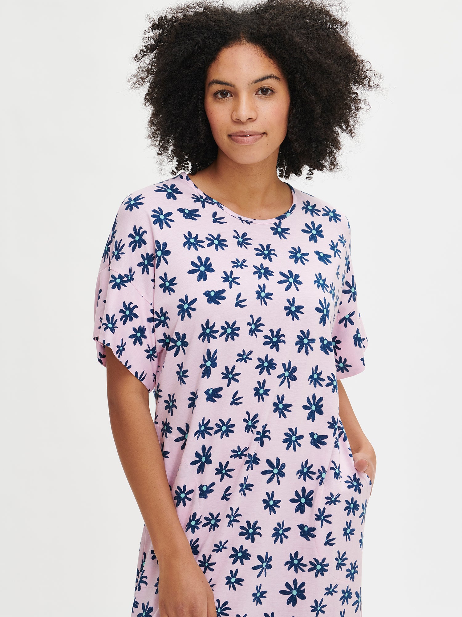 Nanson women's floral-patterned pink Marketta kaftan with side pockets and side slits, featuring sleeve cuffs finished with a wide band, worn by the model in a close-up front view.