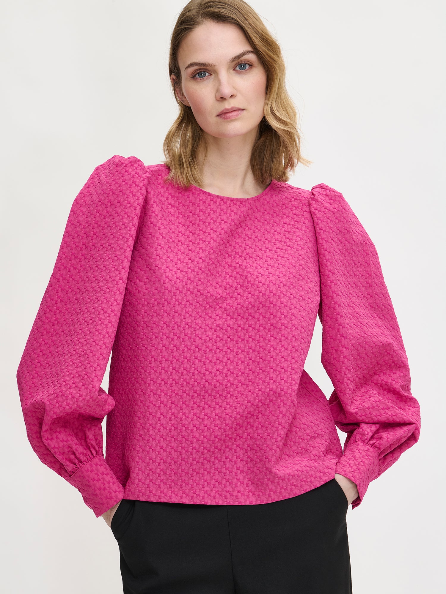 Nanso's stylish women's blouse in pink features a beautiful textured surface, on a model