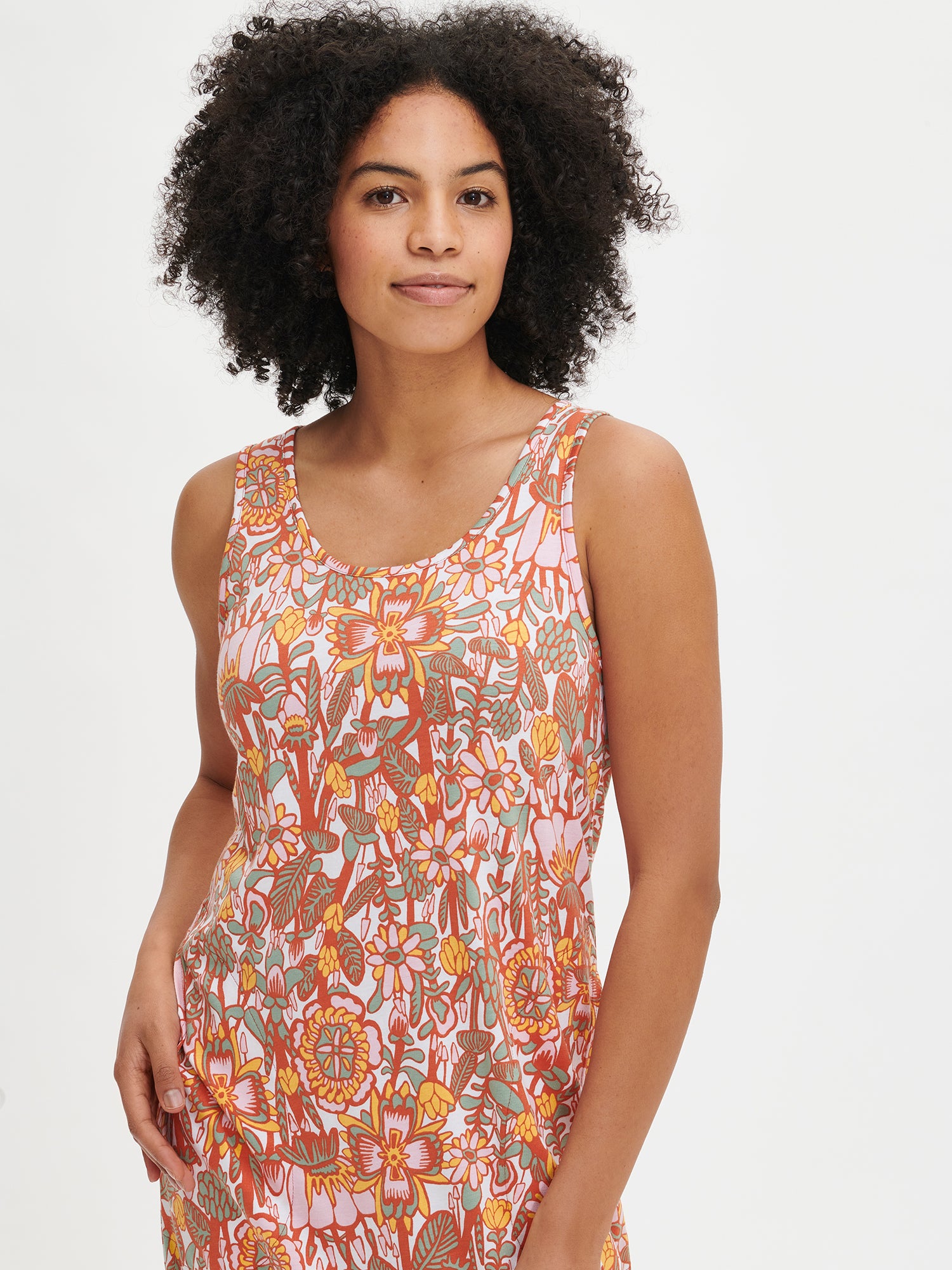 Nanso women's floral-patterned multicolored knee-length sleeveless Oodi nightgown with side pockets, a round neckline, and armholes finished with binding, worn by the model in a close-up front view.
