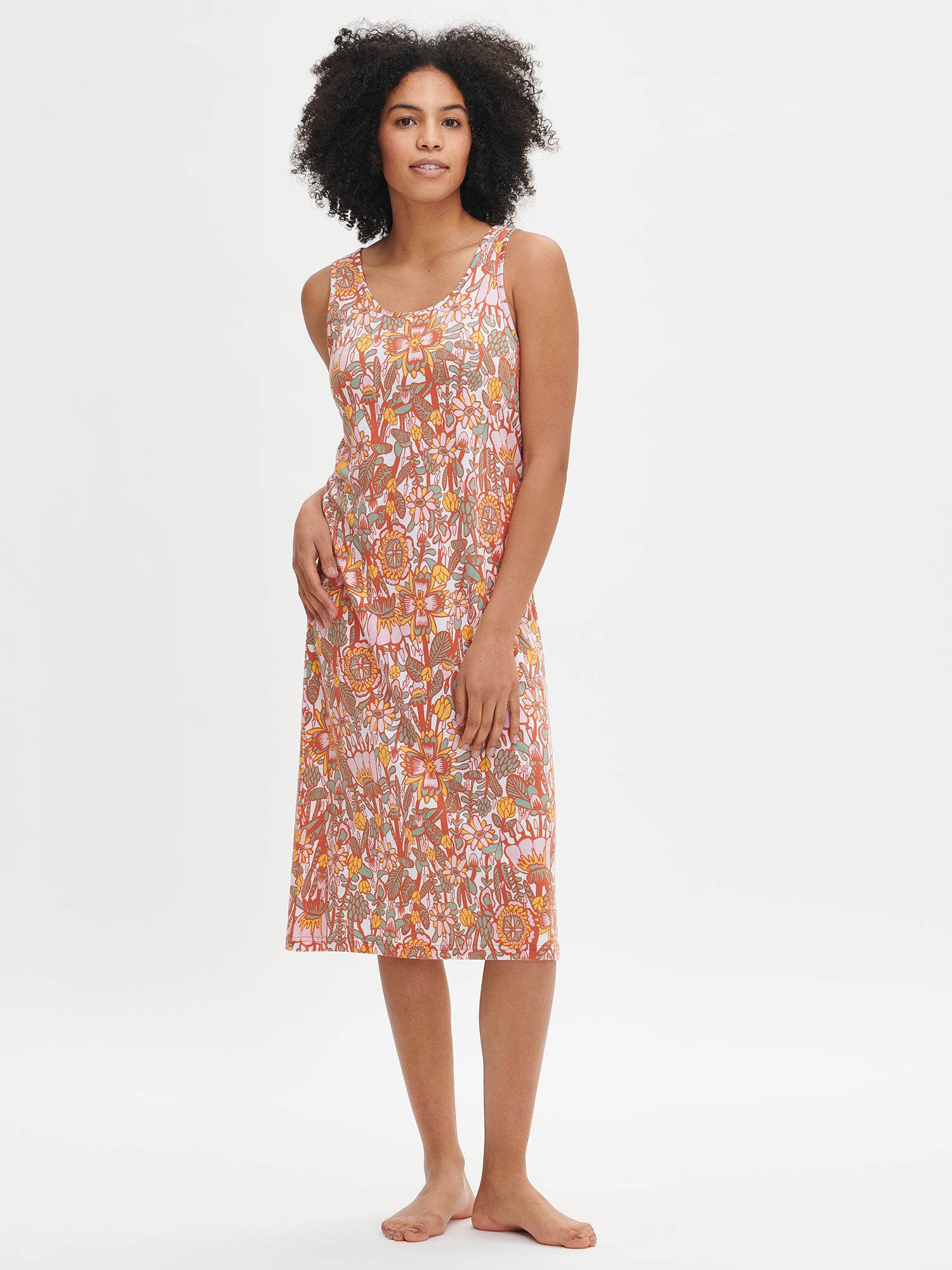 Nanso women's floral-patterned multicolored knee-length sleeveless Oodi nightgown with side pockets, a round neckline, and armholes finished with binding, worn by the model.