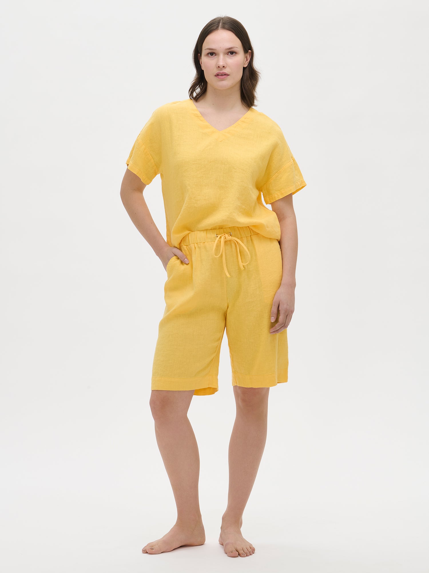 Nanso women’s yellow Sarastus linen shorts on the model, front view. Styled with a matching yellow linen top.