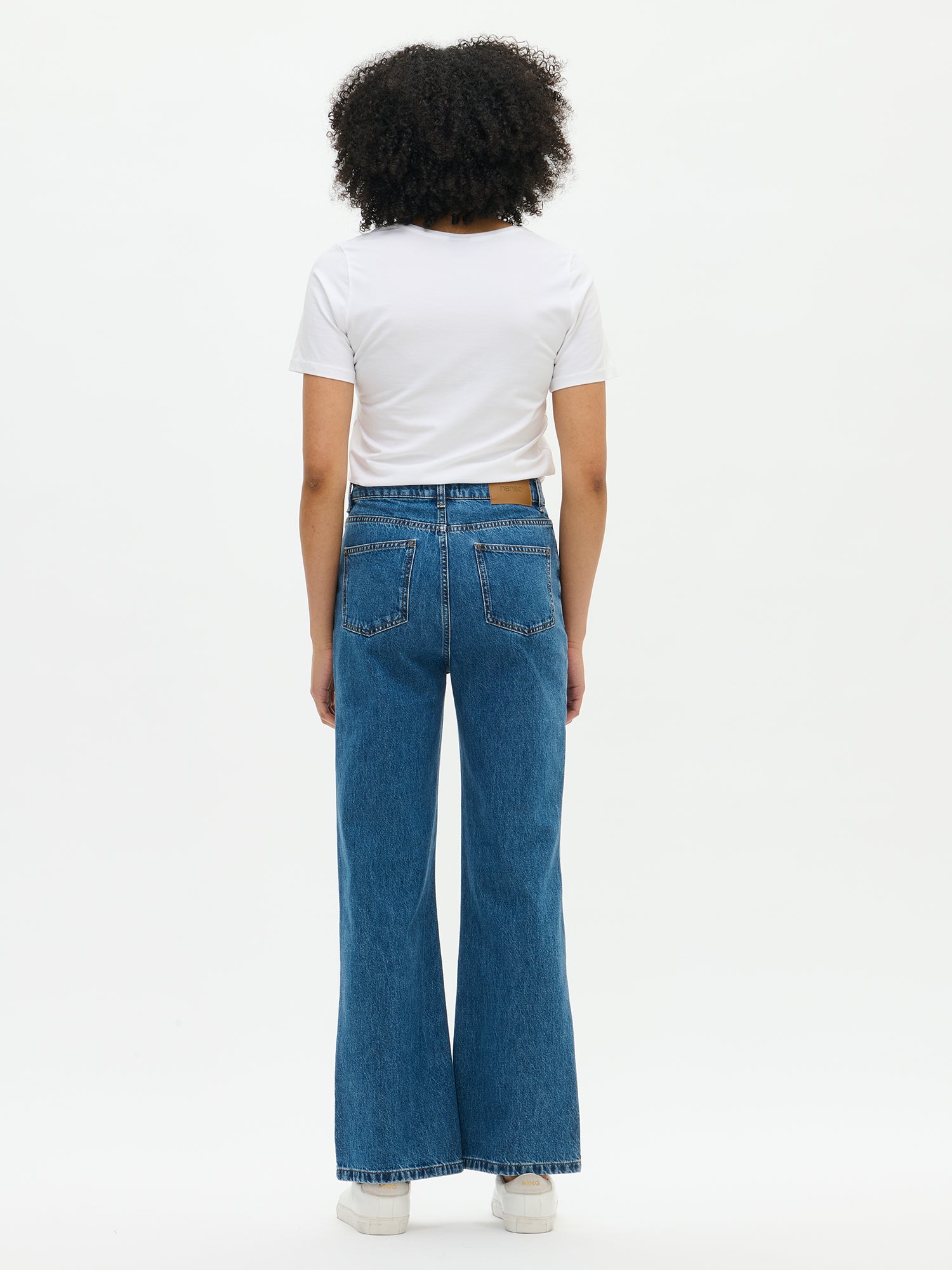 Nanso women’s trendy blue Levee jeans with wide legs, back view on the model. Classic denim cut with back pockets and a flattering flare.