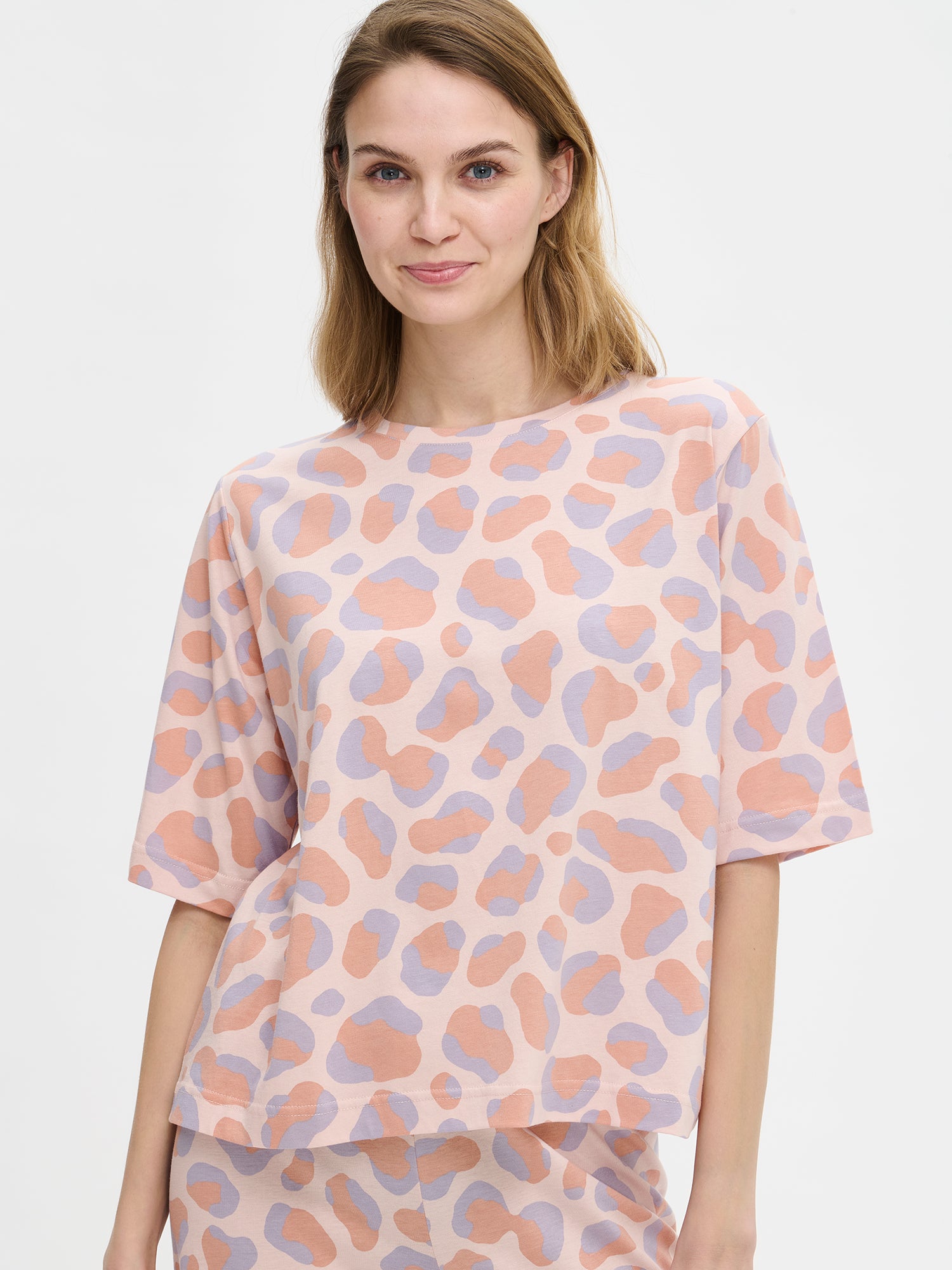 Nanso women’s pink Pantteri T-shirt with elbow-length sleeves, round neckline and straight fit. Panther-pattern. Hem reaches the hip. Shown on model front view.