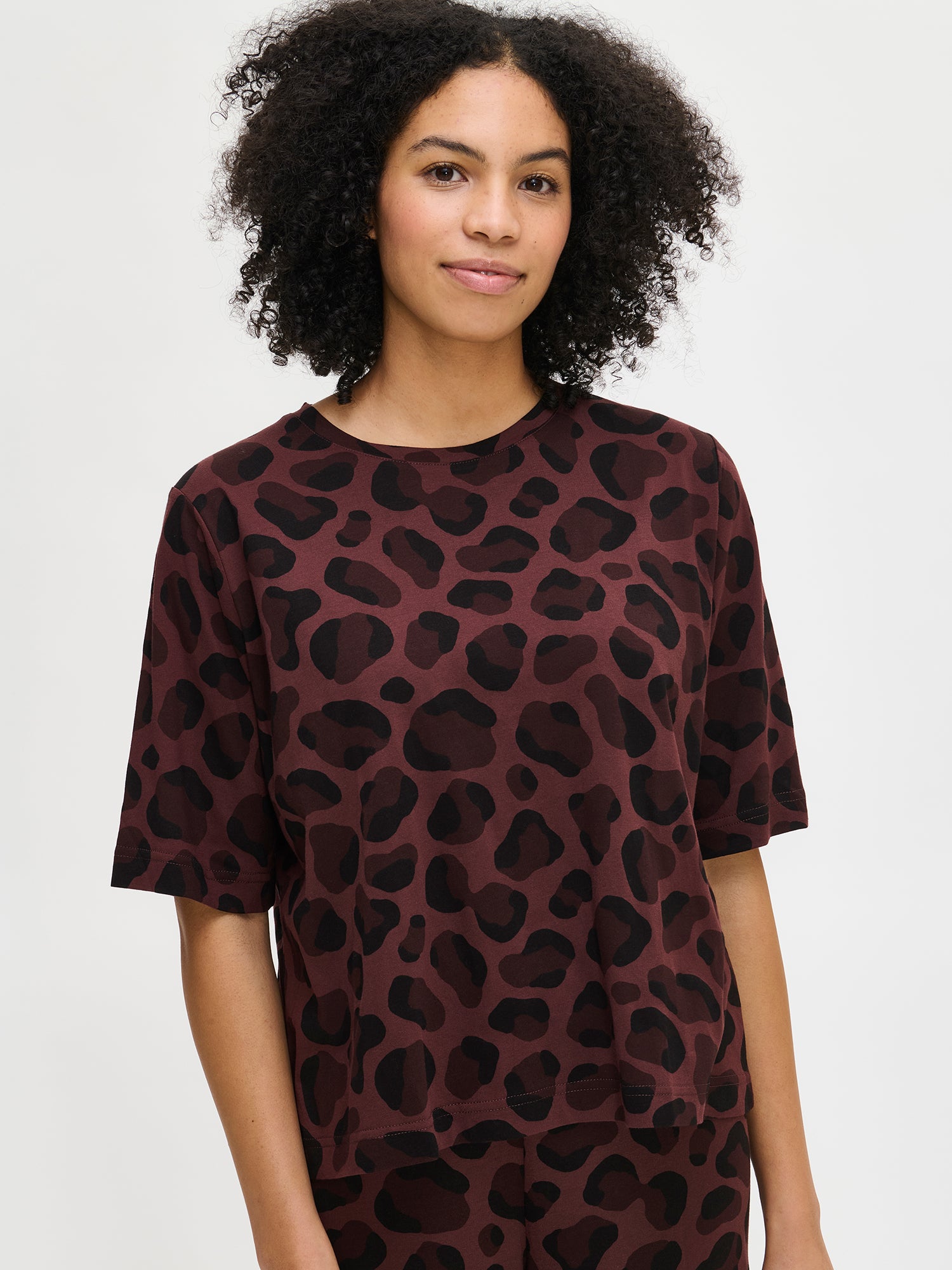 Nanso women’s brown Pantteri T-shirt with elbow-length sleeves, round neckline and straight fit. Panther-pattern. Hem reaches the hip. Shown on model front view.
