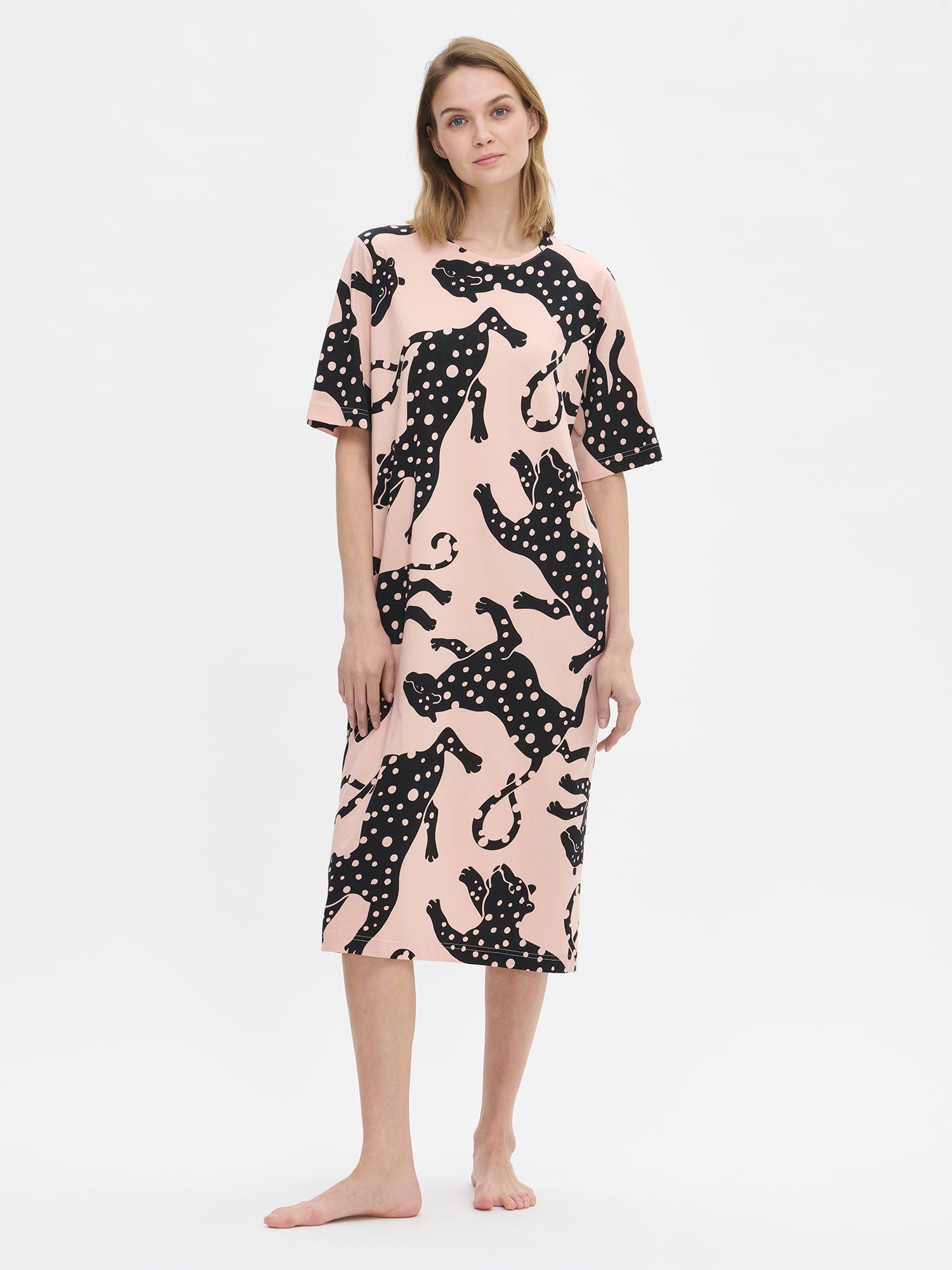 Nanso women’s long pink Leonora nightgown with elbow-length sleeves and round neckline, worn by model from the front. Straight-cut hem falls below the knees.