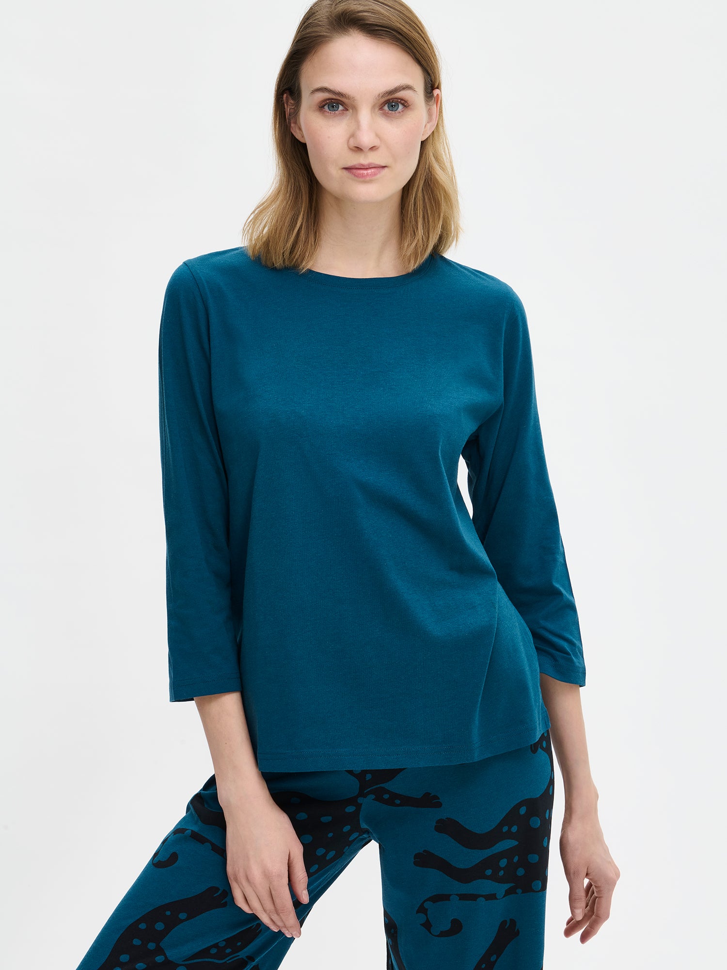 Nanso women’s blue Leonora pyjama, close-up worn by model. Shows round neckline and Leonora patterned trousers.