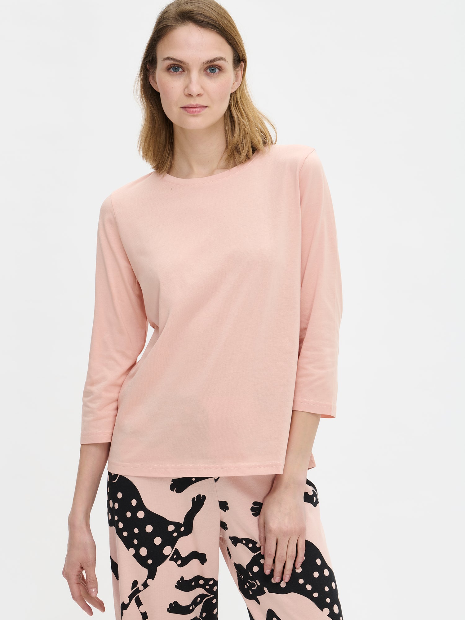 Nanso women’s pink Leonora pyjama, close-up worn by model. Shows round neckline and Leonora patterned trousers.