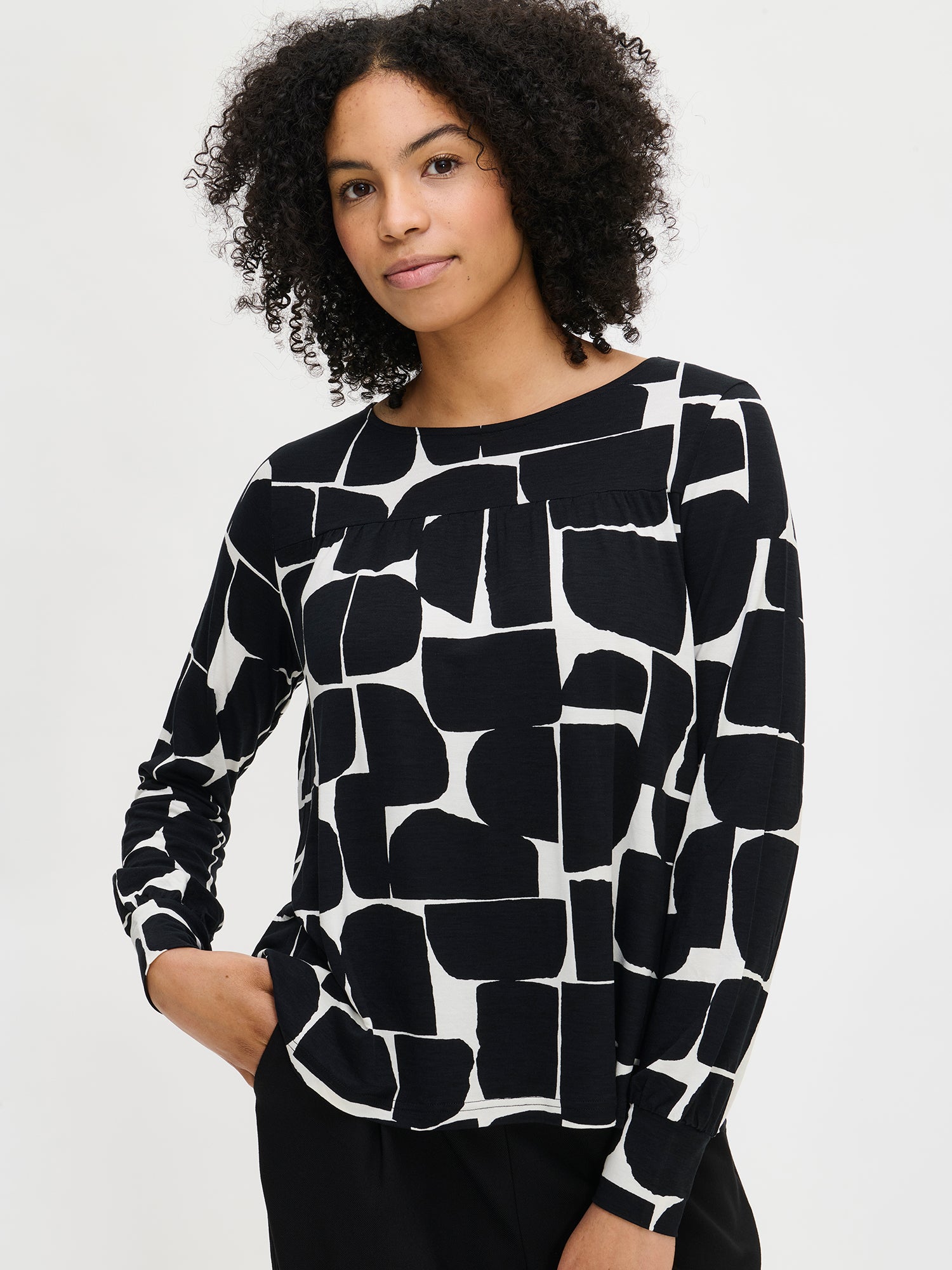 Nanso women’s black and white patterned Muuri top in viscose–elastane, round neckline and full-length sleeves, worn by model in close-up view.