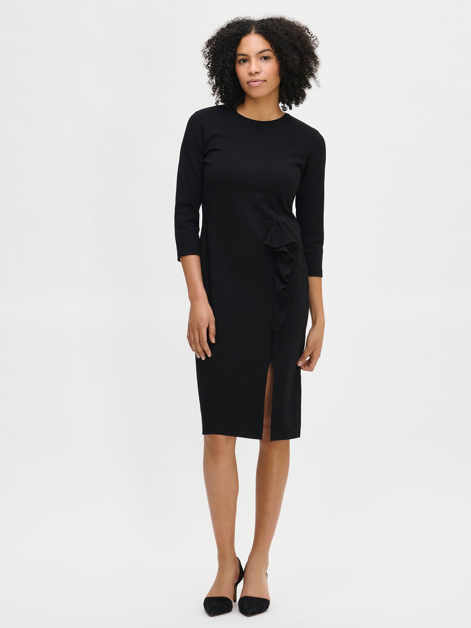 Nanso women’s black Opera dress, knee-length fitted style with round neckline, three-quarter sleeves, and frill detail with slit, worn by model in full-body photo.