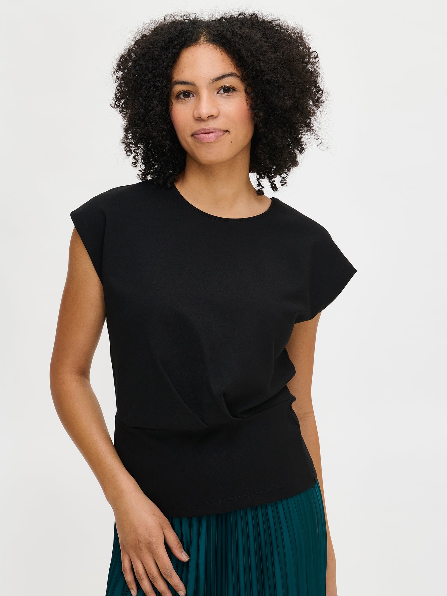 Nanso women’s Elegia blouse – timeless Finnish design in soft black knit with cap sleeves and pleated waist. Image close-up in size S.