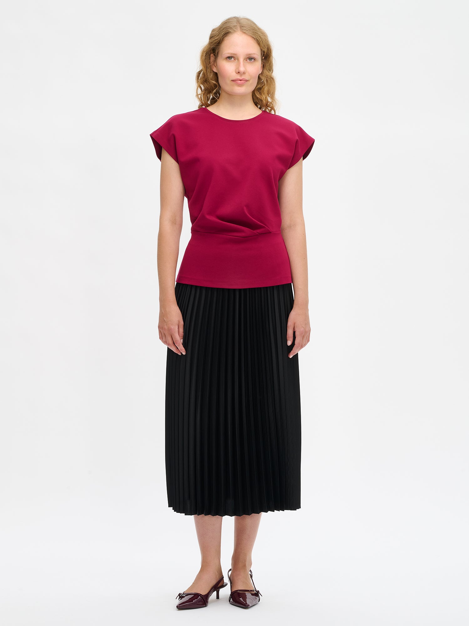 Nanso women’s Elegia blouse – timeless Finnish design in soft burgundy knit with cap sleeves and pleated waist. Image in size S, front