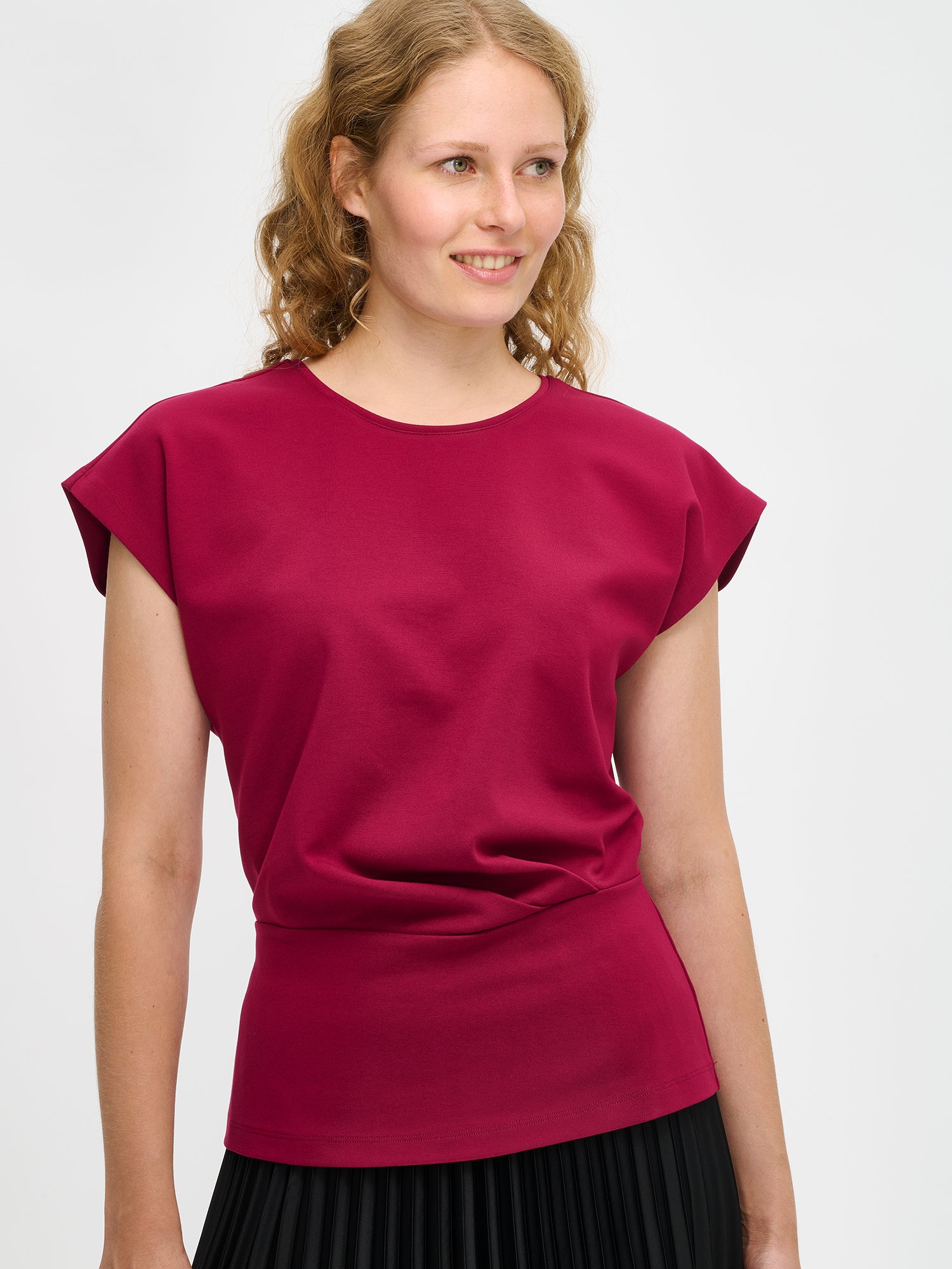 Nanso women’s Elegia blouse – timeless Finnish design in soft burgundy knit with cap sleeves and pleated waist. Image in size S, close-up