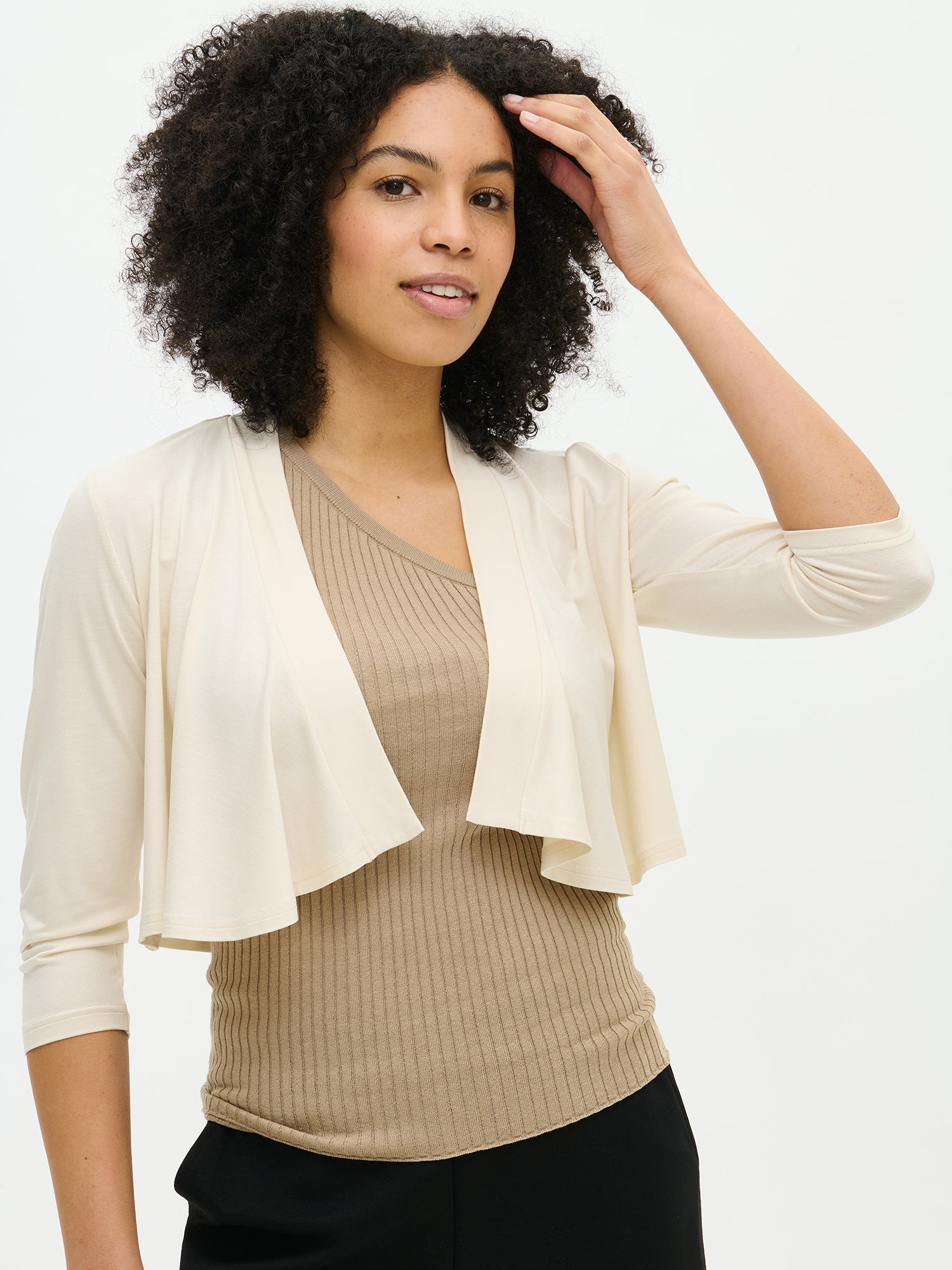 Nanso women's off white solid-coloured Serenadi bolero in a close-up on the model. Cropped length that reaches the chest. Curved front edges, 3/4-length sleeves and a neckline finished with a narrow trim.