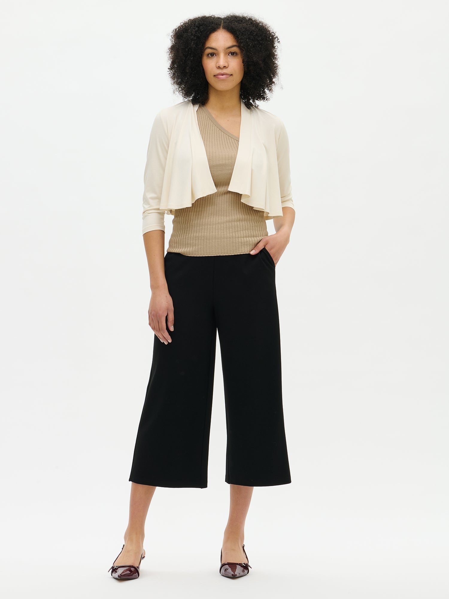 Nanso women's off white solid-coloured Serenadi bolero on the model. Cropped length that reaches the chest. Curved front edges, 3/4-length sleeves and a neckline finished with a narrow trim.