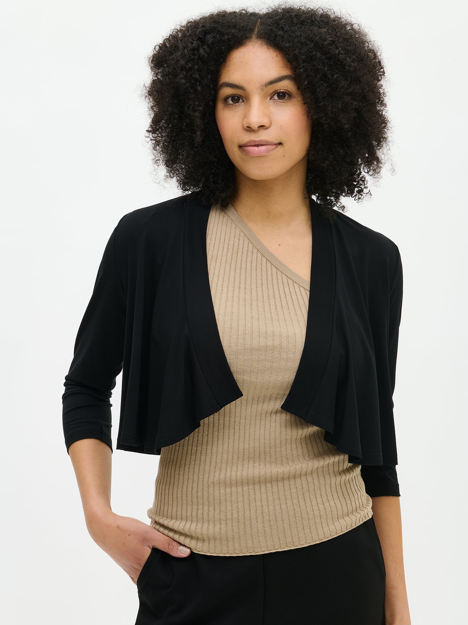 Nanso women's black solid-coloured Serenadi bolero in a close-up on the model. Cropped length that reaches the chest. Curved front edges, 3/4-length sleeves and a neckline finished with a narrow trim.