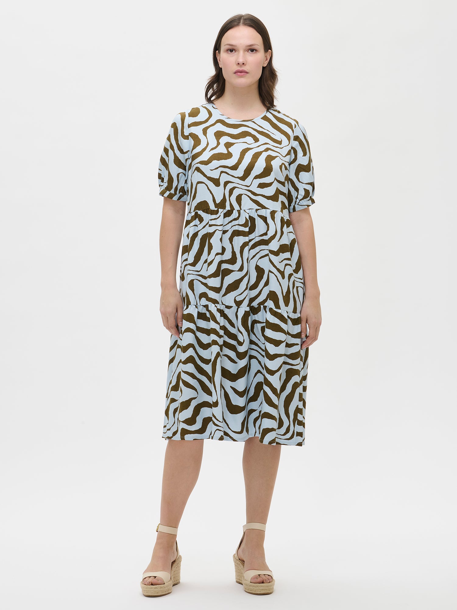 Women's beautiful patterned Savanna midi dress in light blue with voluminous frill layers and short puff sleeves on a model