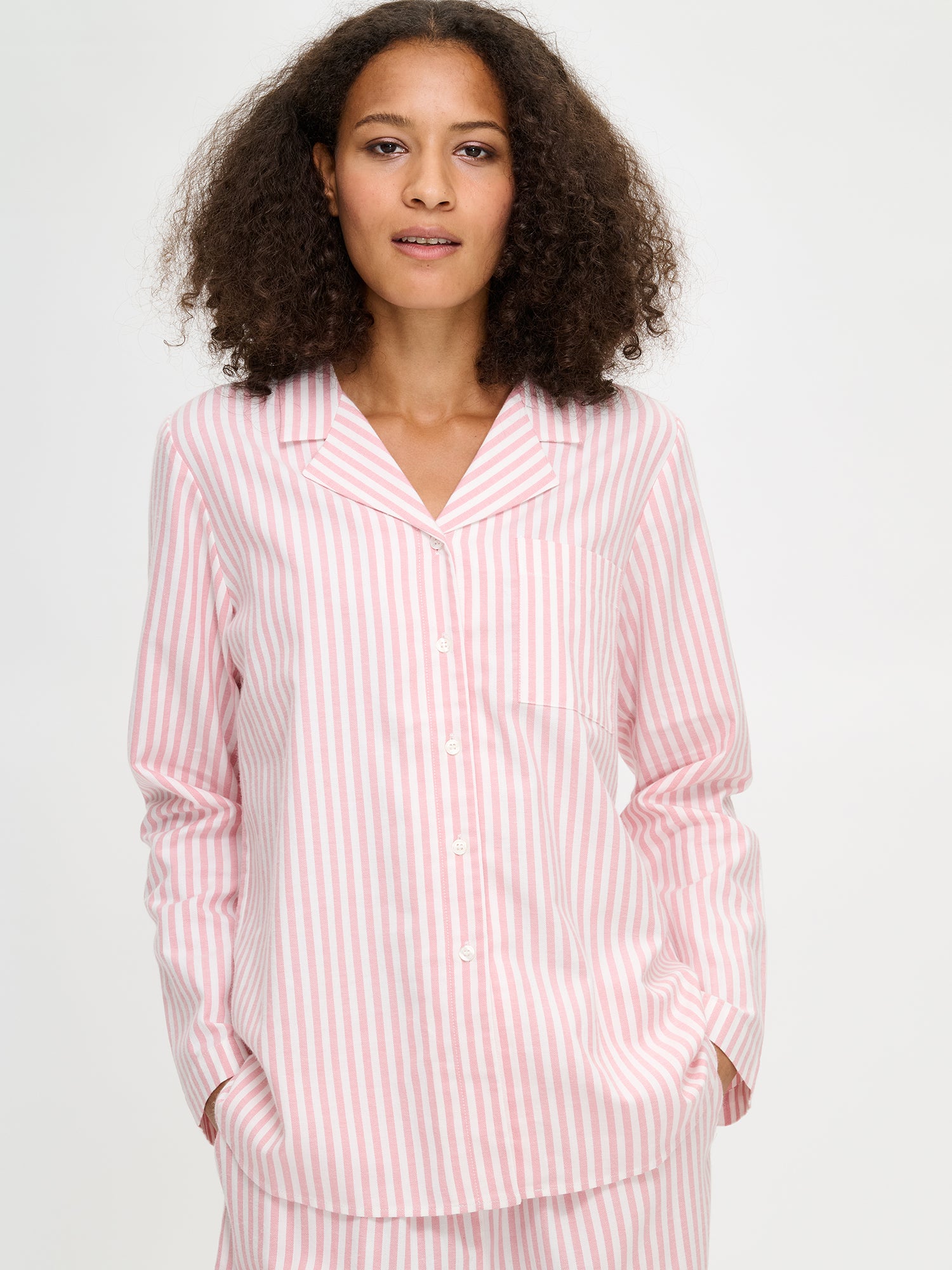 Nanso Polka pink women’s flannel shirt with button placket and chest pocket, half-body image worn by model.
