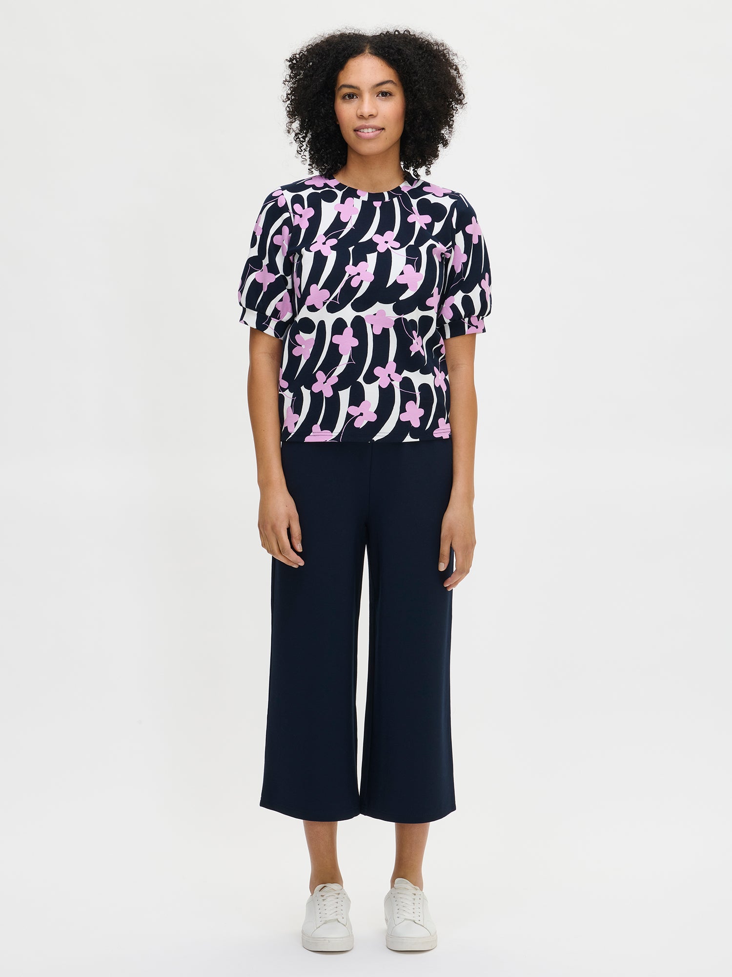 Women's Alma trousers in a dark blue color for a relaxed fit. The trousers feature side pockets and an elastic waistband. Worn by a model in size S.