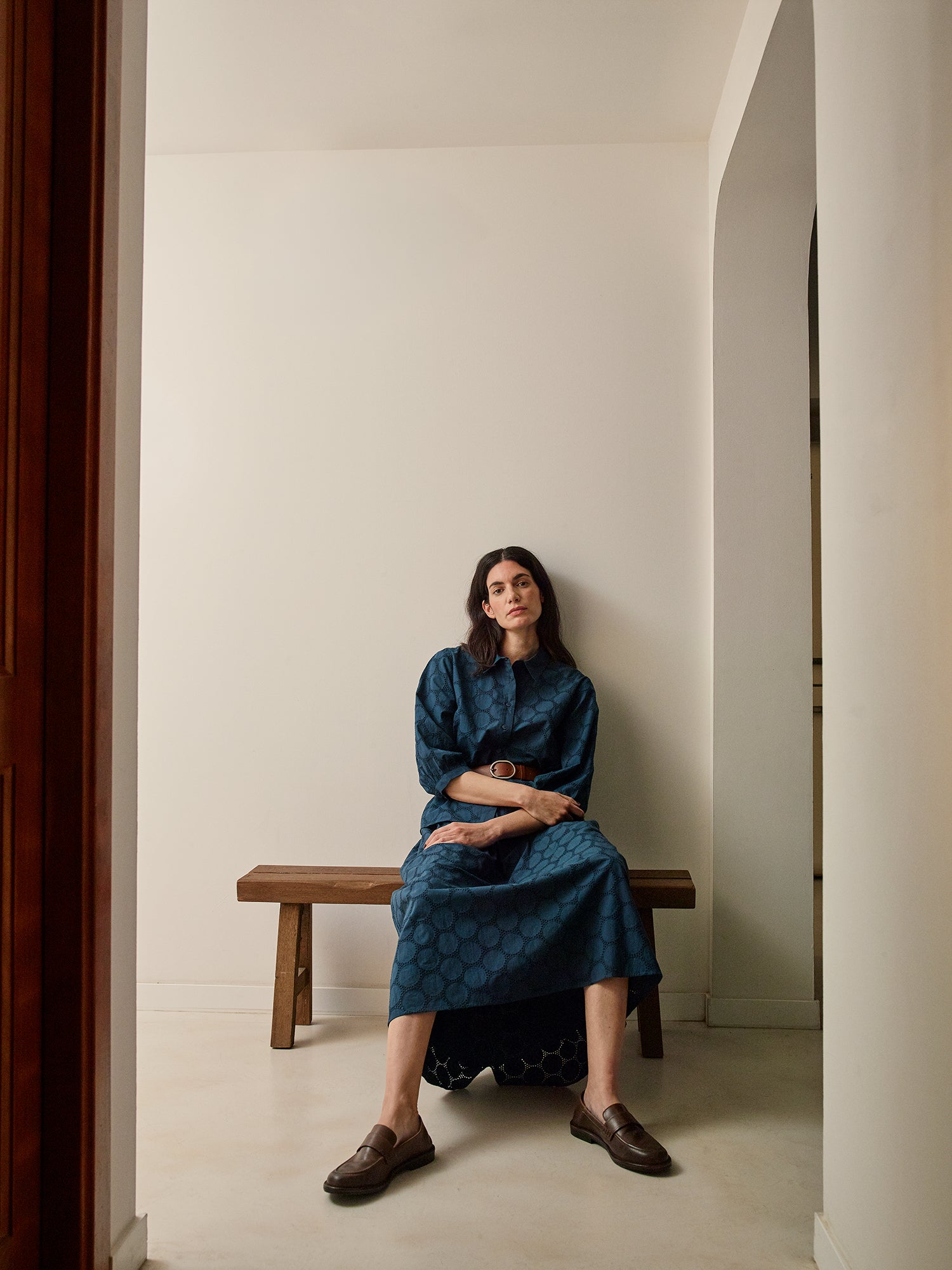 nanso women's stylish dark blue Siiri blouse for women, featuring beautiful embroidered fabric, classic collar, buttons and 3/4 sleeves, on a model with a matching skirt.