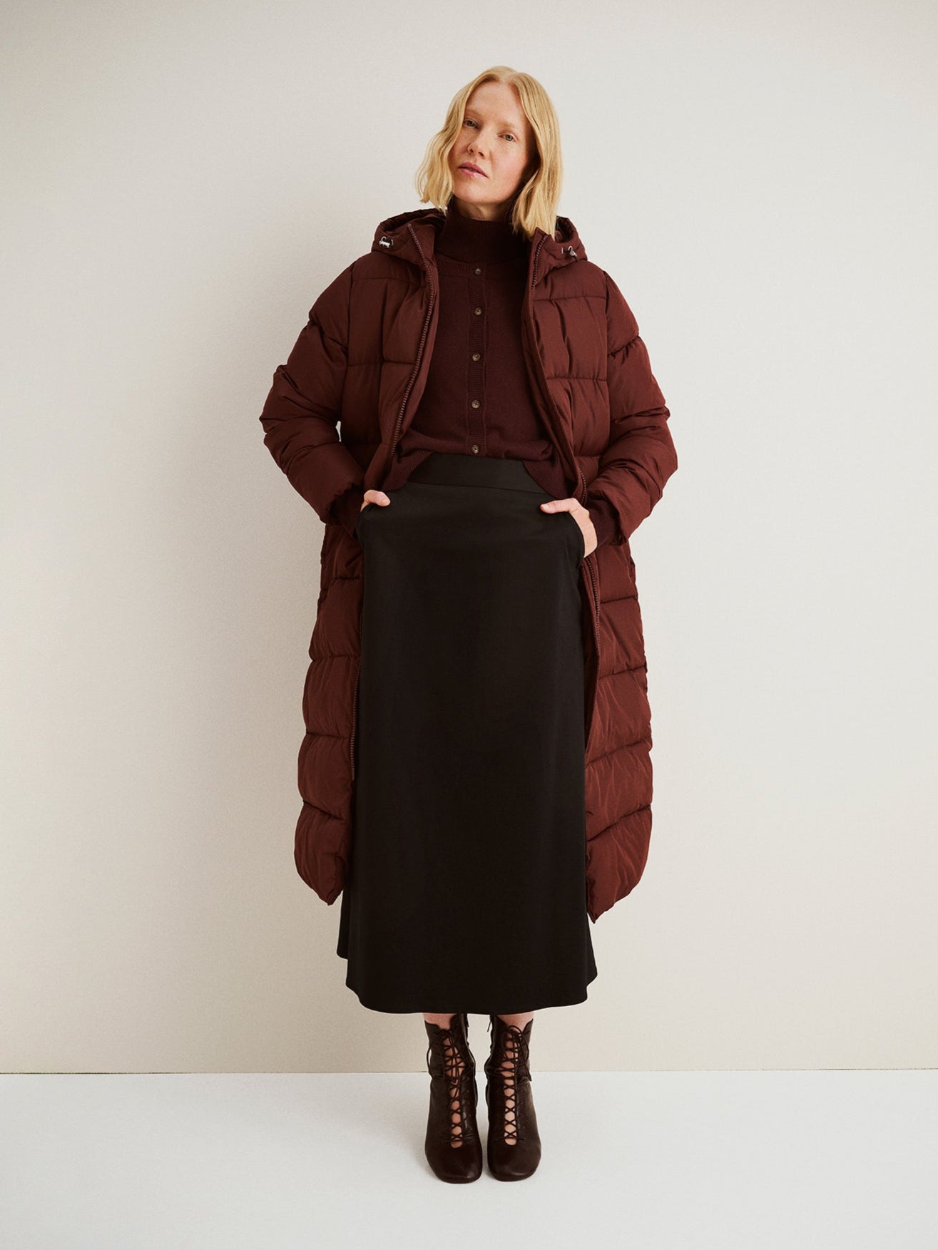 The Lumi Long Pink Puffer Coat in beige offers cozy warmth with its lightweight, puffy insulation. 