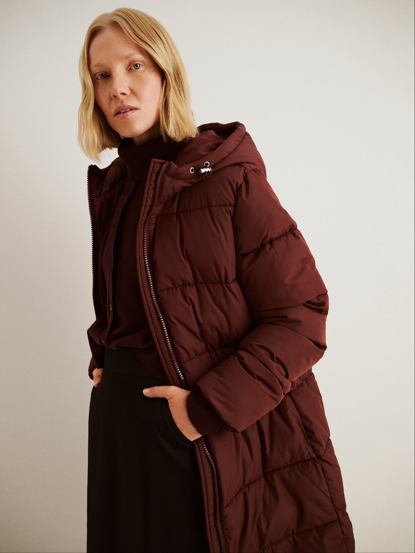 The Lumi Long Pink Puffer Coat in beige offers cozy warmth with its lightweight, puffy insulation. 