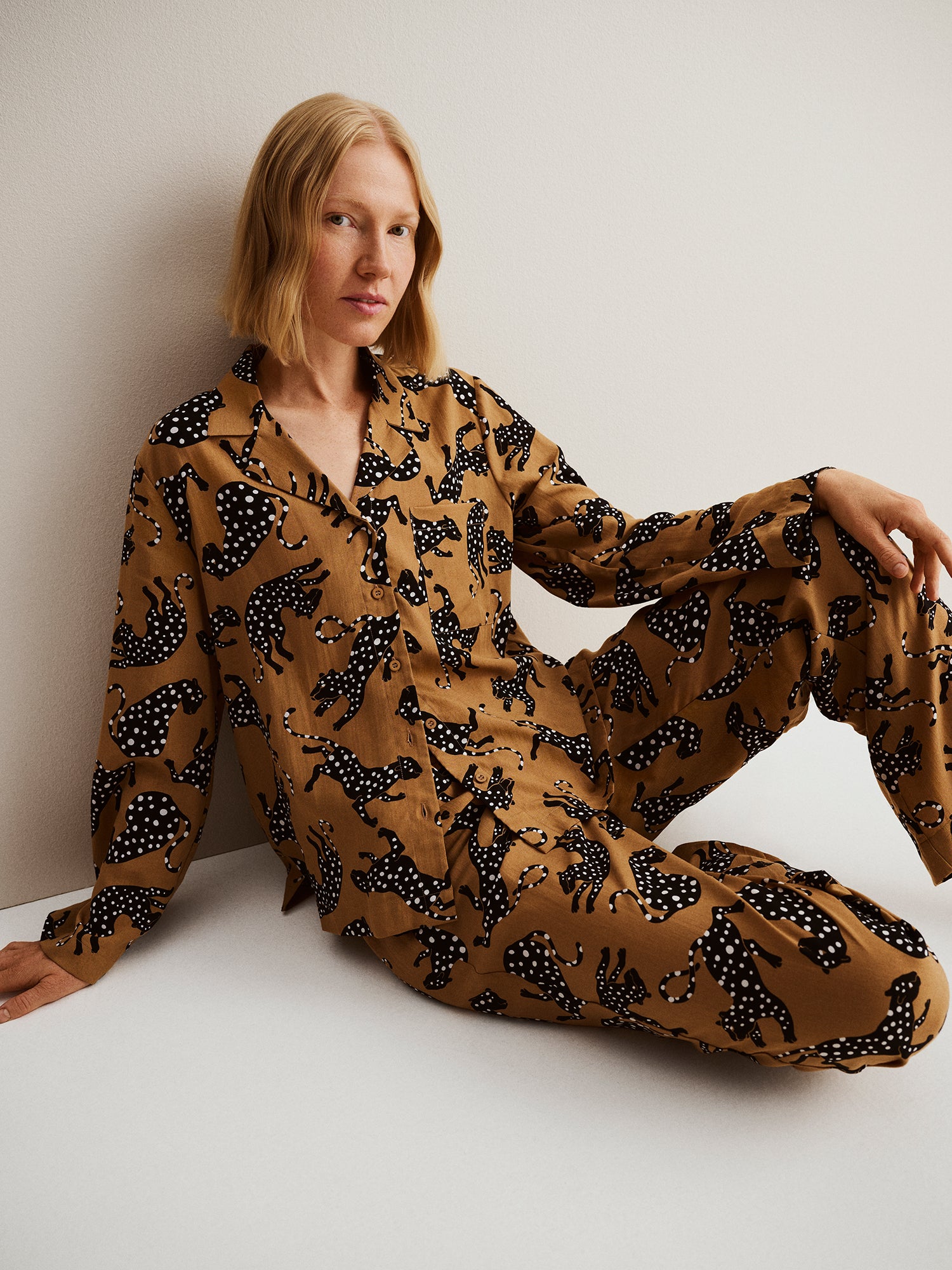 Nanso women's beige Pieni Leonora blouse with patterned fabric, shirt collar and buttons, worn by a model sitting