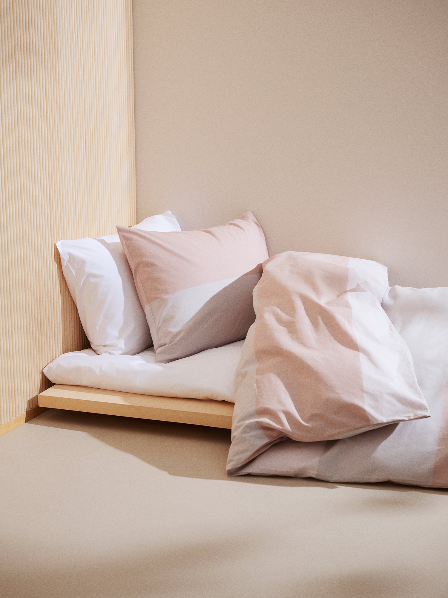 Nanso's  beige Trio duvet cover set features a beautiful wide striped pattern, on a bed