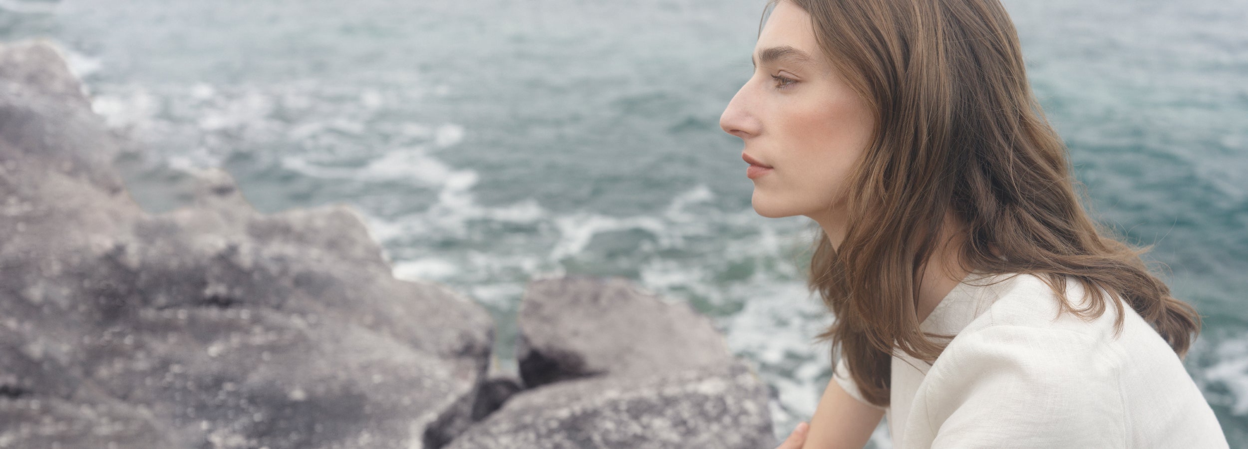 Nanso beige linen dress on a female model by the sea
