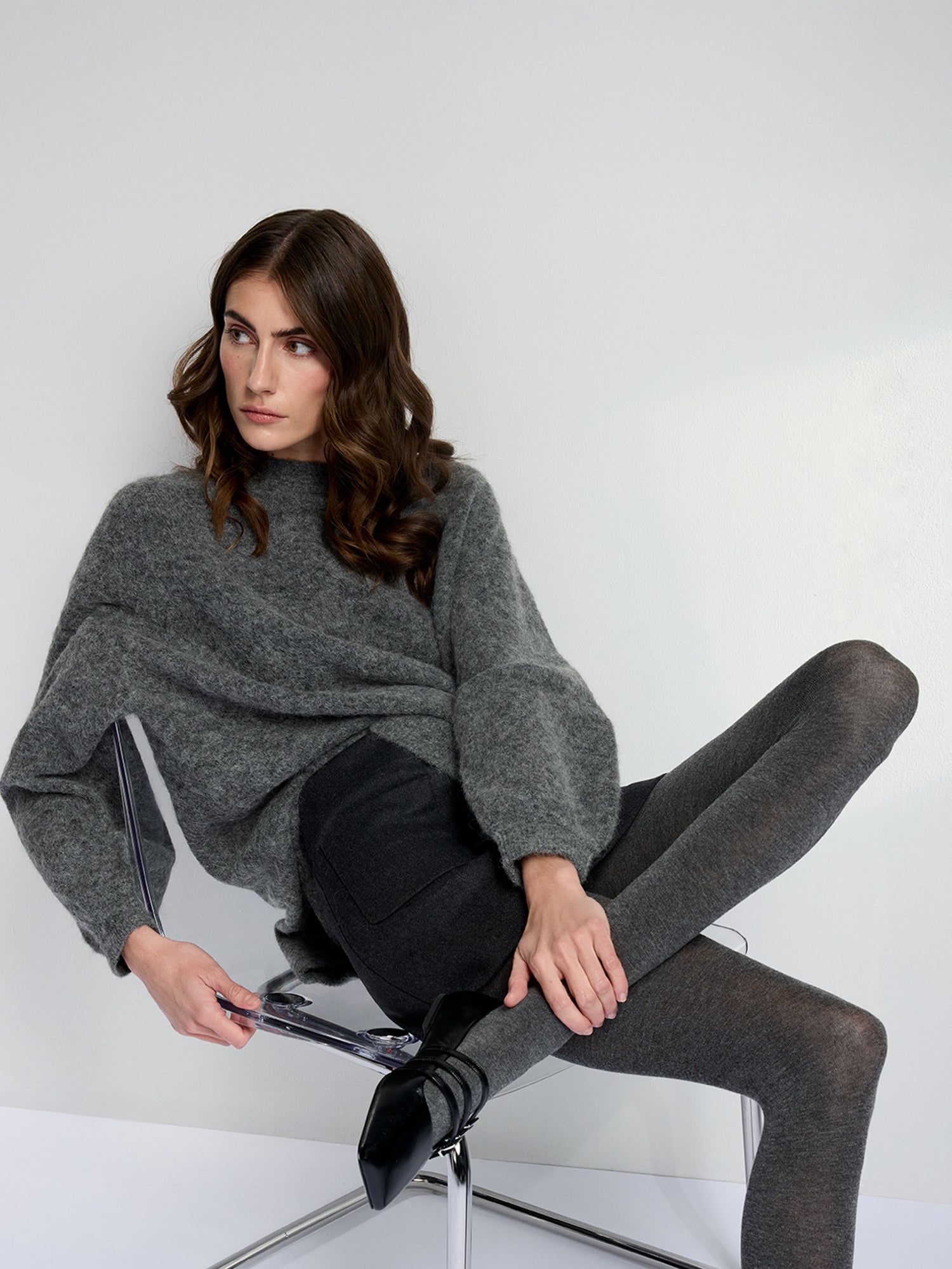 Luxuriously soft classic grey cashmere-blend tights, on a model with a gray knit sweater and black skirt