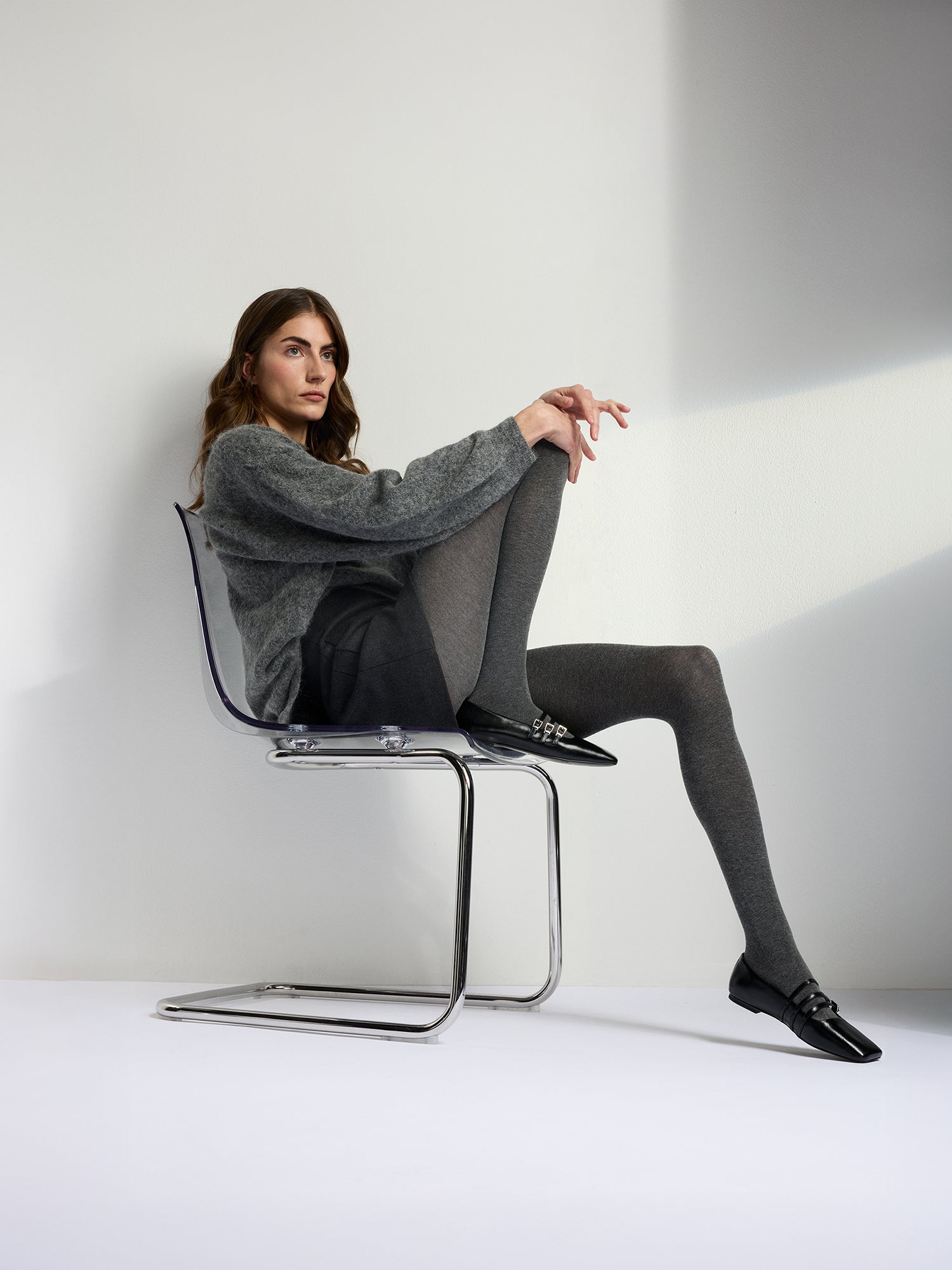 Luxuriously soft classic grey cashmere-blend tights, on a model with a gray knit sweater and black skirt