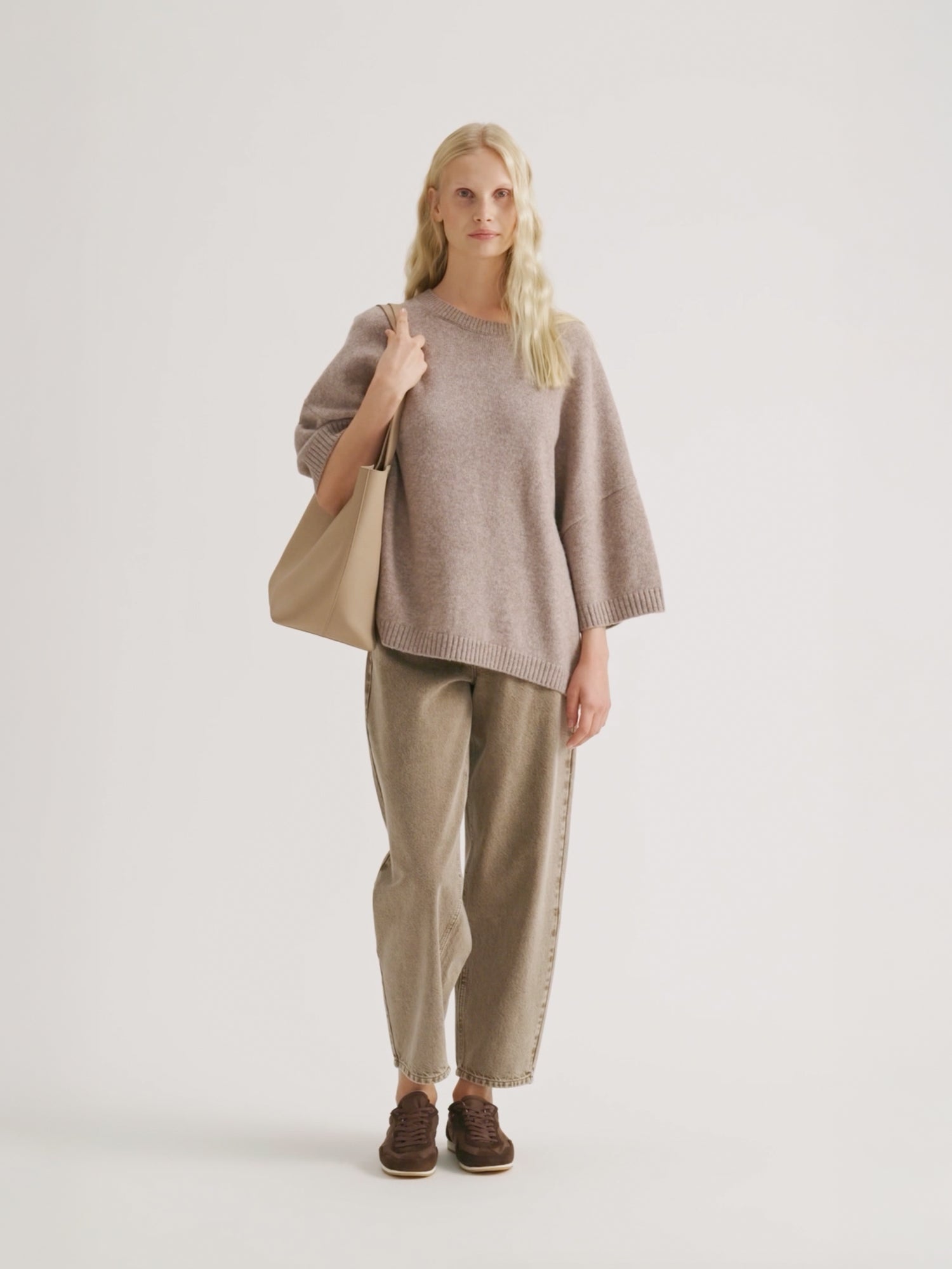 Woman wearing a beige Lana knit and Rento jeans