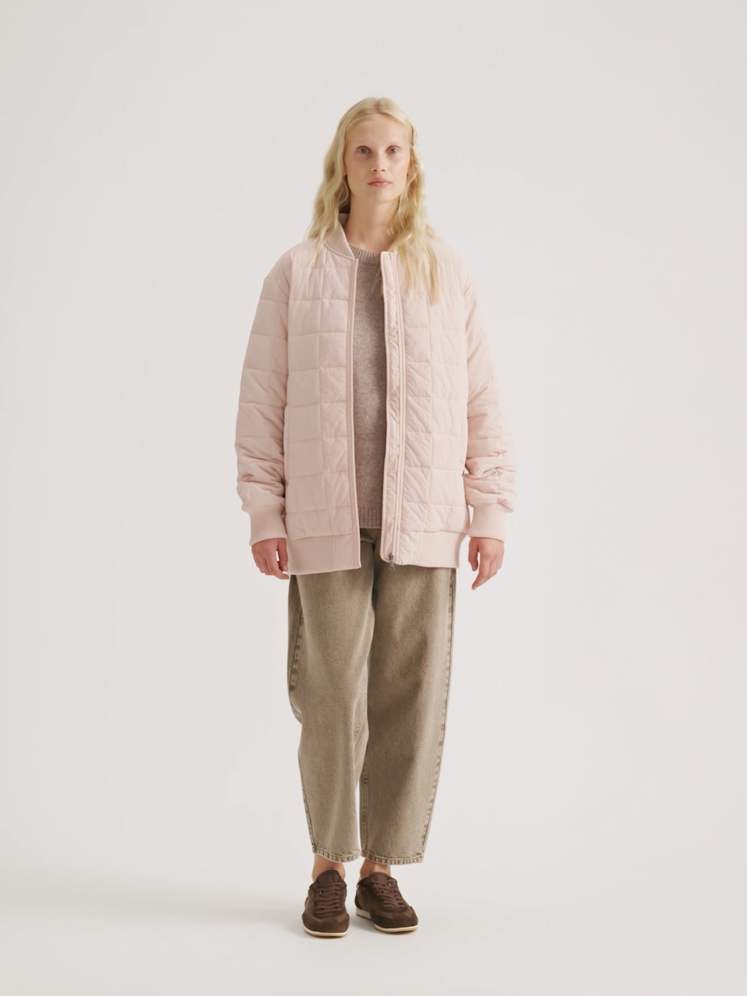 Woman wearing the MERJE Quilted Bomber Jacket in Light Rose