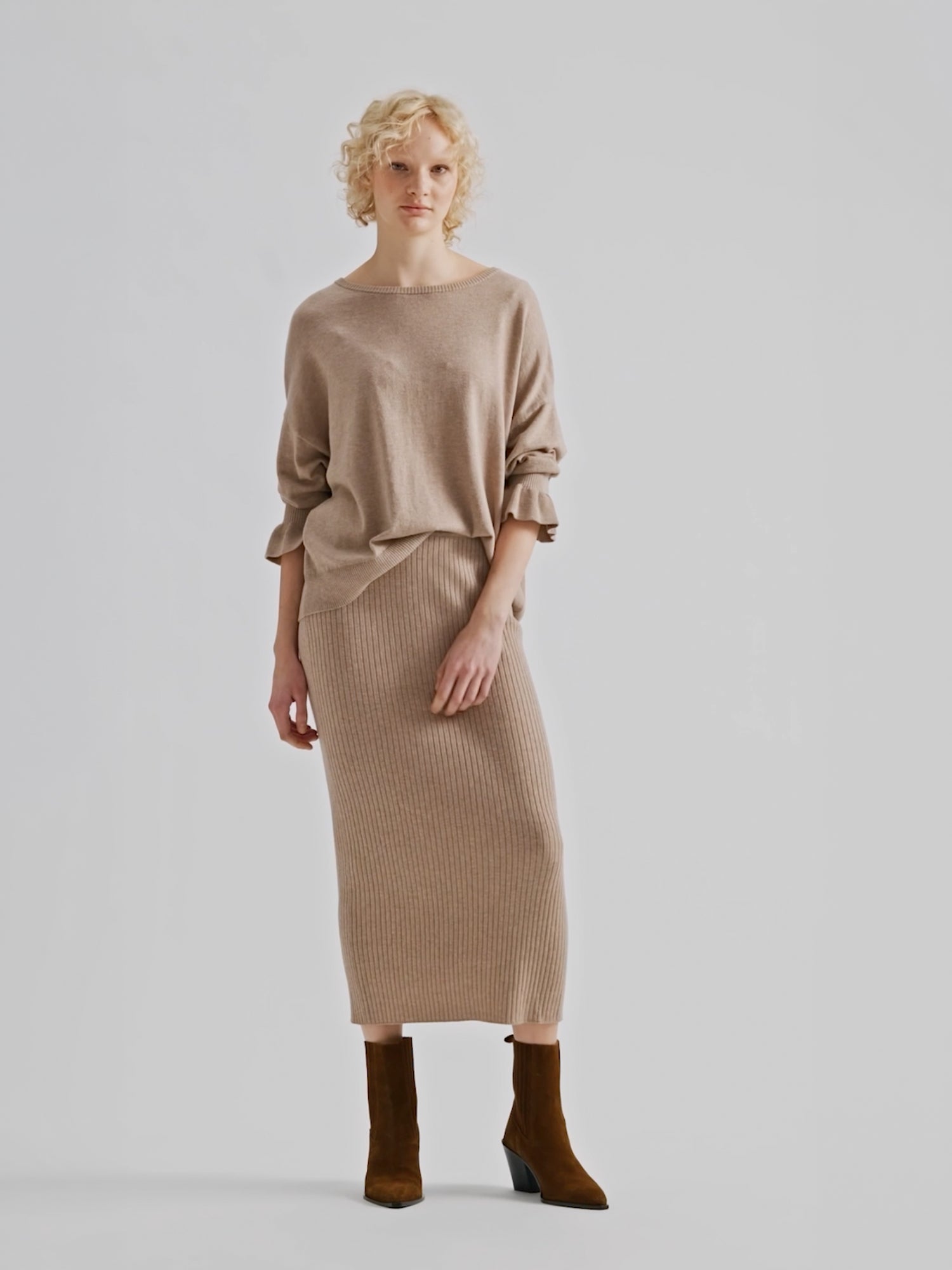 Nanso women's simply stylish and lightweight Villis Frilla knit jumper is charmingly finished with beautiful frill details at the cuffs, pictured on a model with a matching knit skirt