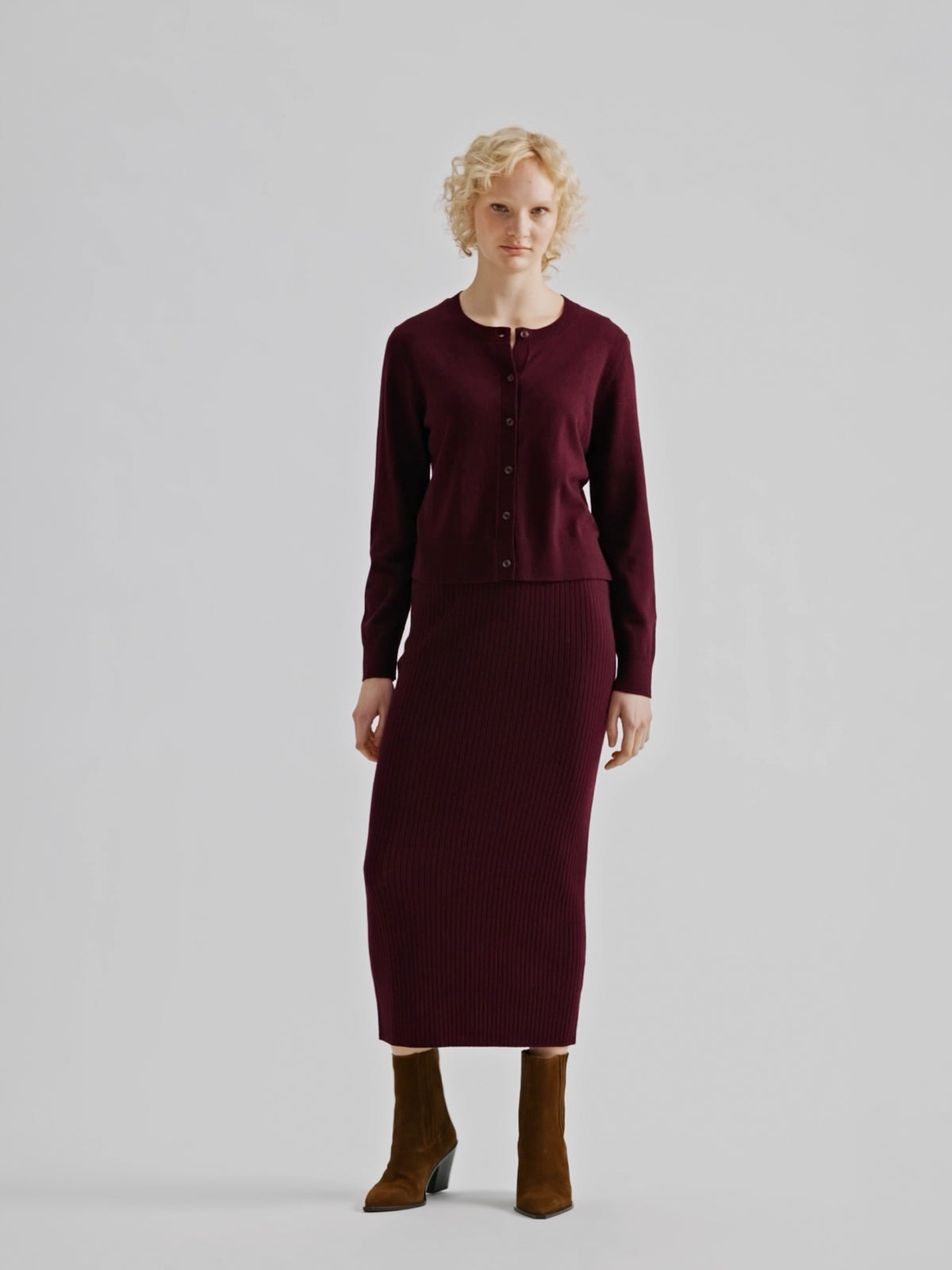Women´s Villis ribbed knit skirt in burgundy crafted from a superior blend of merino wool and cotton, on a model with a matching cardigan