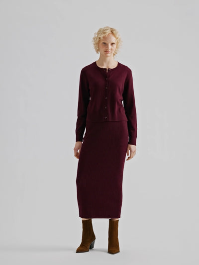 Women´s Villis ribbed knit skirt in burgundy crafted from a superior blend of merino wool and cotton, on a model with a matching cardigan